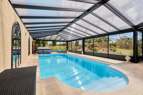 une piscine intérieure avec un toit en verre dans l'établissement La surville, à Surville