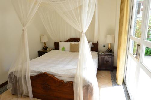 a bedroom with a bed with mosquito netting at Papago International Resort in Chishang