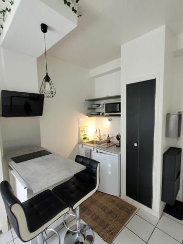 une petite cuisine avec une table et une armoire noire dans l'établissement Studio Buffon, à Avignon