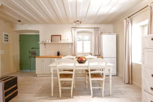 a kitchen with a white table and chairs at Teacher's House in Meganisi