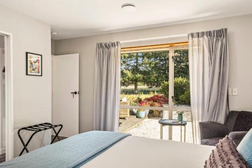 a bedroom with a bed and a window at Birdsong Alley Bed and Breakfast in Hanmer Springs