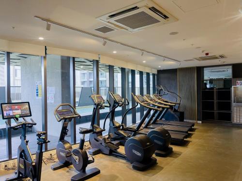 a gym with treadmills and ellipticals in a building at Realm Apartments by CLLIX in Adelaide