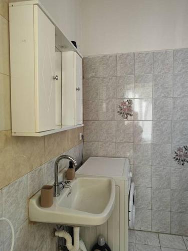 a bathroom with a sink and a white cabinet at Odysseus family house in Stefaniá