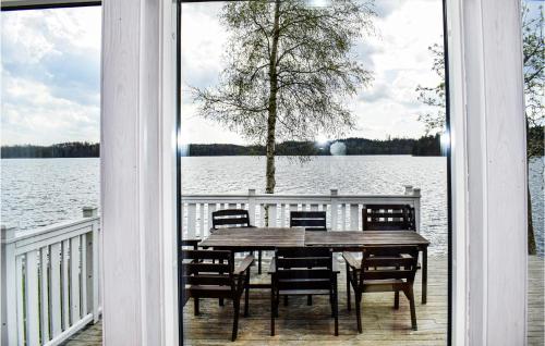 a table and chairs on a porch with a view of a lake at Awesome Home In Hyltebruk With Sauna in Hyltebruk