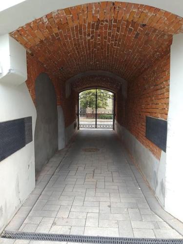 an empty hallway with a brick wall and a brick ceiling at Apartament przy Ratuszu in Płock