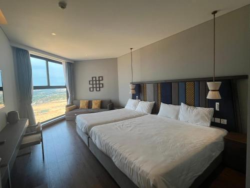 a hotel room with a large bed and a window at Apec Mandala Cham Bay Mui Ne in Ấp Thiẹn Ái