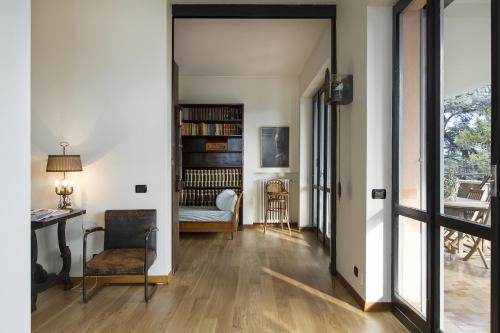 a living room with a table and a chair and a book shelf at Appartamento Il Parco Cernobbio in Cernobbio