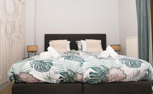 a bedroom with a large bed with a tropical bedspread at Lila 23 appartement 1 Arnoud in Blankenberge