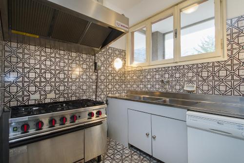 a kitchen with a stove and a sink at Appartamento Il Parco Cernobbio in Cernobbio