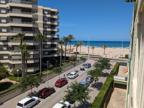 eine Straße mit Autos auf einer Straße neben dem Strand in der Unterkunft Apartamento Los Juncos - 50m playa - Sólo familias - Parking gratuito - WIFI - TV 55" 4K - PS5 in Playa de Gandia