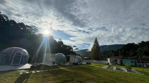 a group of domes in a yard with the sun shining at The Starry Dome Couple Room in Cameron Highlands