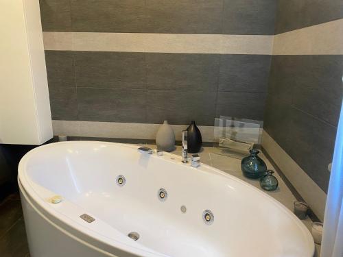 a white bath tub in a bathroom with vases at La Canonica di Soglio in Camerano Casasco