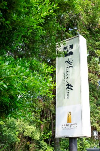 a sign on a pole in front of a tree at HOTEL Villamure Ogori -ADULT ONLY- in Tosu