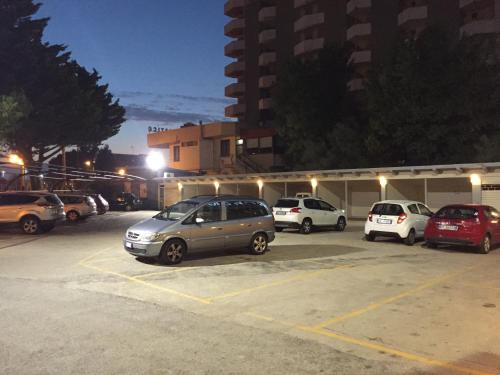 a group of cars parked in a parking lot at night at Hotel Promenade in Montesilvano