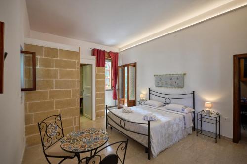 a bedroom with a bed and two tables and chairs at B&B IreneMarchese Gluten Free in Taviano