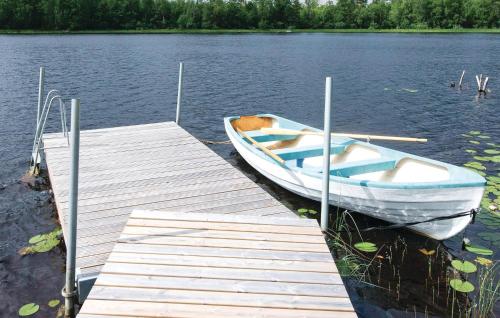 a boat is docked at a dock on a lake at Holiday Home Skogstorp Gård Holmsjö in Holmsjö