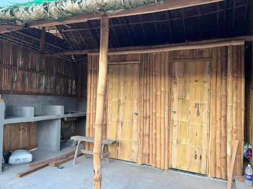 a building with two wooden doors and a bench at Tiny house Calatagan in Calatagan