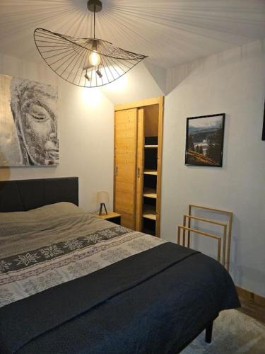 - une chambre avec un grand lit et un ventilateur dans l'établissement Charmant T1 montagnard proche parc thermal, à Saint-Gervais-les-Bains