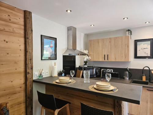 une cuisine avec une table avec des assiettes et des verres à vin dans l'établissement Charmant T1 montagnard proche parc thermal, à Saint-Gervais-les-Bains