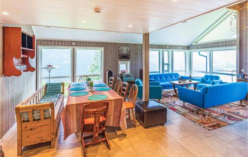 a dining room with a table and blue chairs at 4 Bedroom Stunning Home In Skjolden in Luster