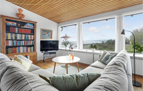 a living room with a couch and a large window at Beautiful Home In Gudhjem in Gudhjem