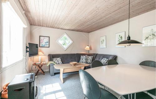a living room with a couch and a table at Risegård, Lejl B in Åkirkeby