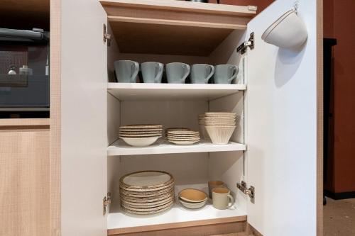 a pantry with plates and bowls and bowls on shelves at THE SECOND Chousei Beach Village 3階建てペット不可 in Jōnouchi