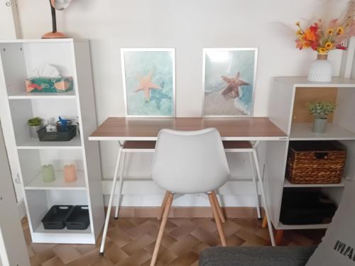 - un bureau avec une chaise blanche dans l'établissement Les pinèdes, à Sète