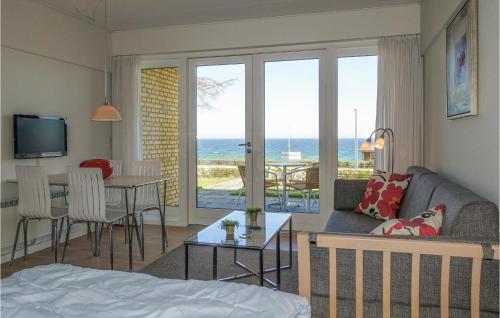 a living room with a couch and a table with a view of the ocean at Lovely Apartment In Allinge With Wifi in Allinge