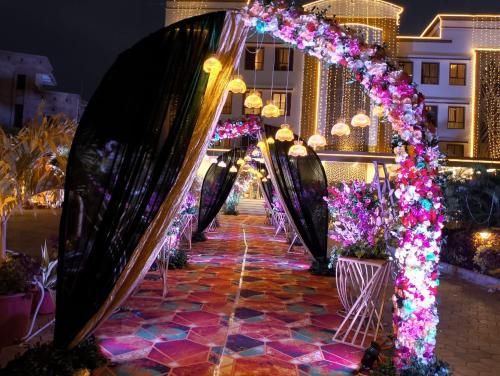 a row of archways with flowers and lights at PUSHPAK HOTEL & CONVENTION in Bhubaneshwar