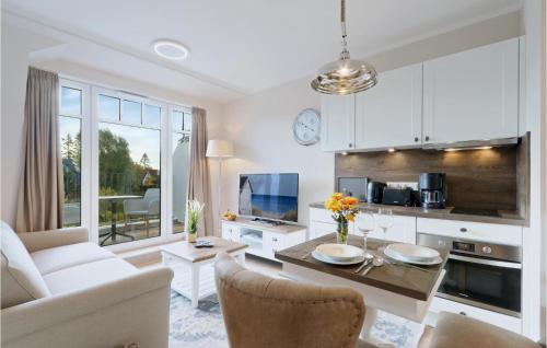 a living room with a table and a kitchen at Baltischer Hof Apartment 50 in Boltenhagen