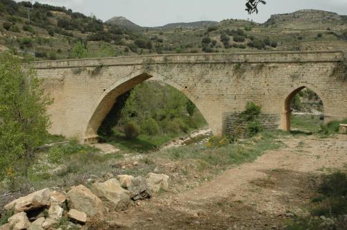 a stone bridge with two arches over a dirt road at Casa Rural Nuri de Rei A y B in Todolella