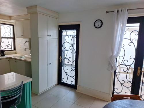eine Küche mit einer Tür mit einer Uhr an der Wand in der Unterkunft Casa de las Dunas in Ciudad Madero