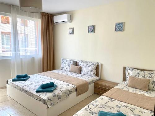 a bedroom with two beds and a window at Rusalka Apart-Residence in Obzor