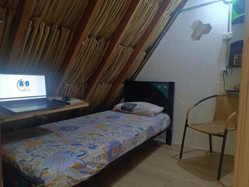 a bedroom with a bed with a laptop on a desk at Bio Coliving Tayrona in Santa Marta