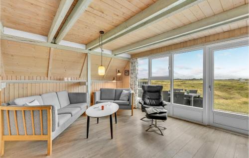 a living room with a couch and a table and chairs at Holiday Home Hvide Sande With A Fireplace 05 in Bjerregård