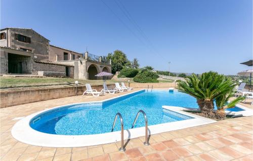 a swimming pool with chairs and a house at Cozy Home In Ragusa With Kitchen in Camemi
