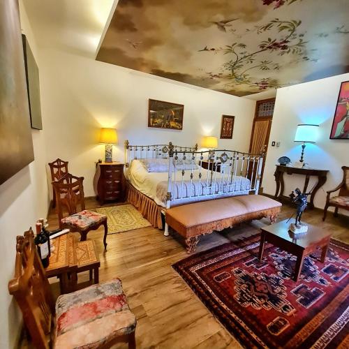 a bedroom with a bed and a living room at Hotel Boutique Casa San Marcos in Quito