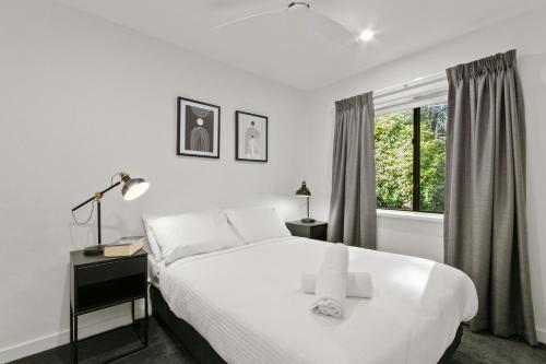 Un dormitorio blanco con una cama y una ventana. en Mowamba B4, en Thredbo