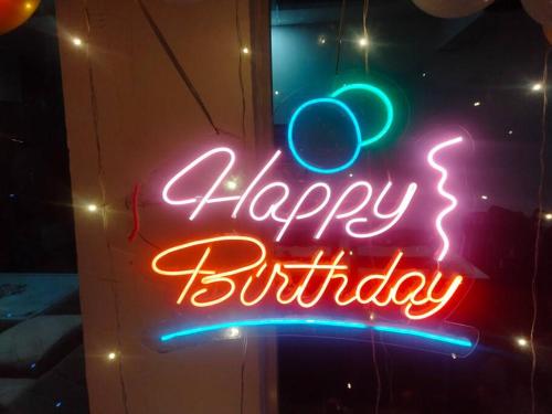 a neon sign that says happy birthday on a window at Honey Villa 3bhk With Private Swiming Pool in Mānakpur