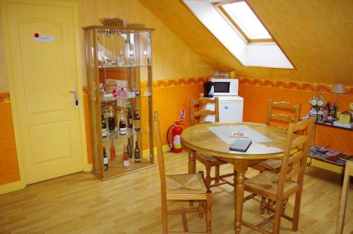 eine Küche mit einem Tisch und einem Glasschrank mit Weinflaschen in der Unterkunft Family DELCOUR in Mailly-Maillet