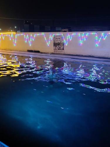 a swimming pool at night with lights on a wall at Honey Villa 3bhk With Private Swiming Pool in Mānakpur