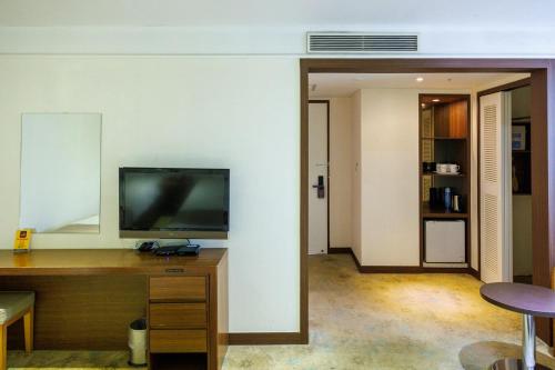 a room with a desk with a television on a wall at Jeju Robero in Jeju