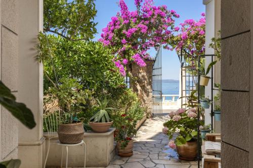 a walkway with flowers and plants in pots at Beach APARTMENT in Podgora