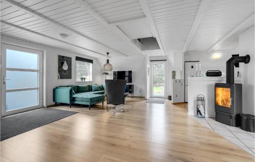ブラーバンドにあるAmazing Home In Blåvand With Kitchenのリビングルーム(緑のソファ、暖炉付)