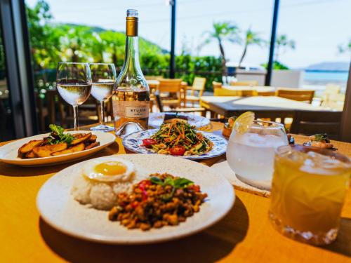 a table with plates of food and a bottle of wine at サンメール座間味 in Zamami