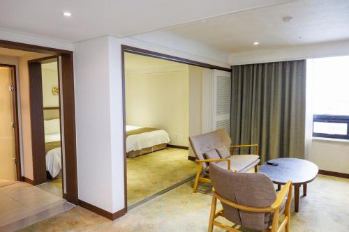 a room with a bed and a table and a mirror at Jeju Robero in Jeju
