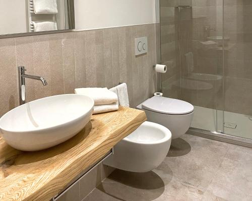 a bathroom with a white sink and a toilet at AmiRooms Affittacamere in Siena