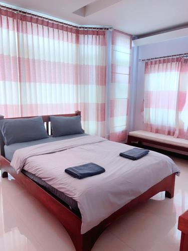a bedroom with a large bed with two towels on it at ณดา เกาะล้าน รีสอร์ท in Ko Larn