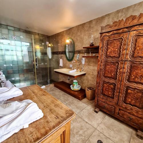 a bathroom with a shower and a sink and a wooden cabinet at Hotel Boutique Casa San Marcos in Quito